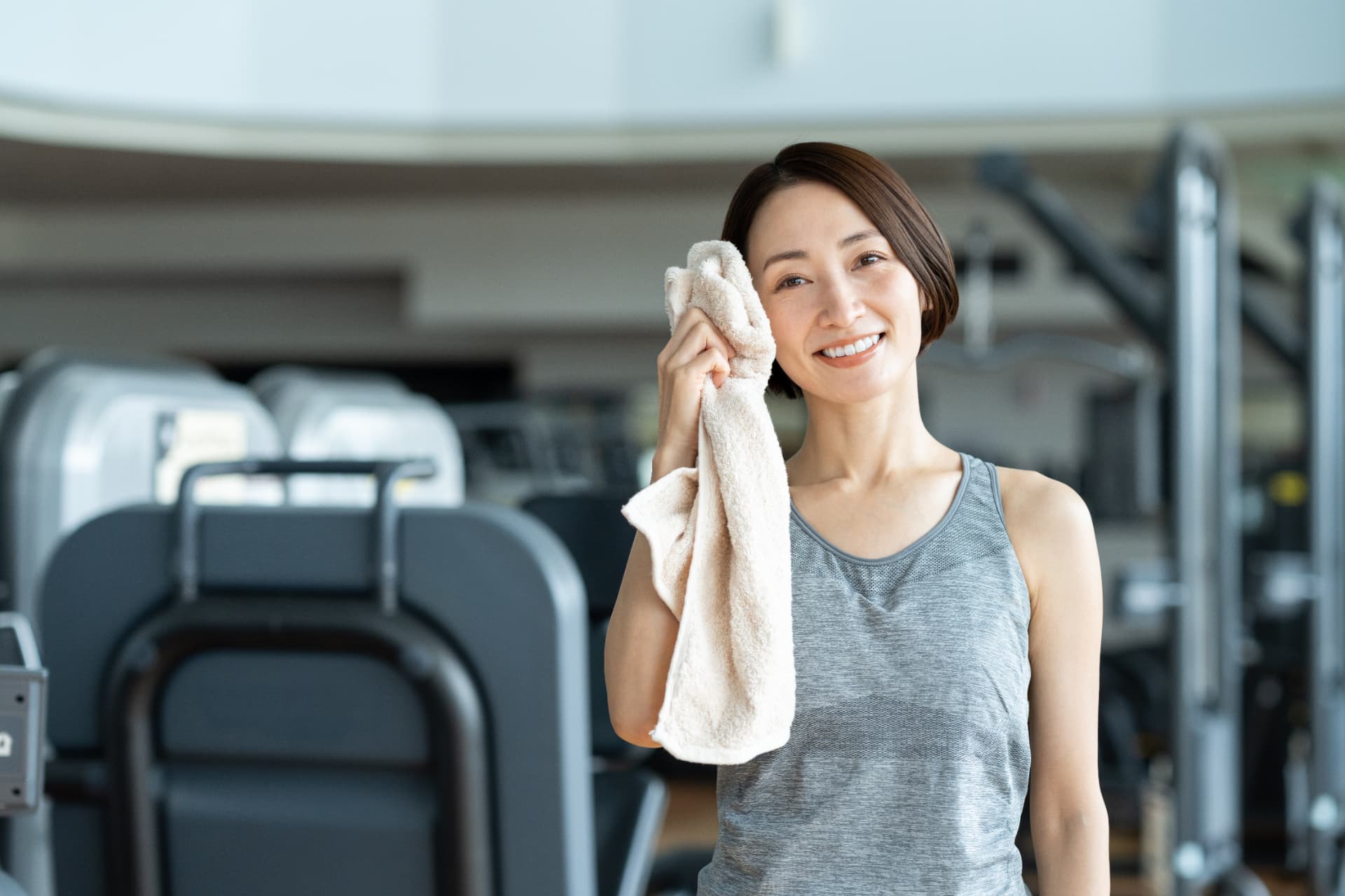 運動後に汗を拭き、晴れやかに微笑む女性